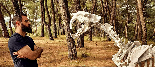 Konstantinos Fais facing his Smilodon Populator sculpture